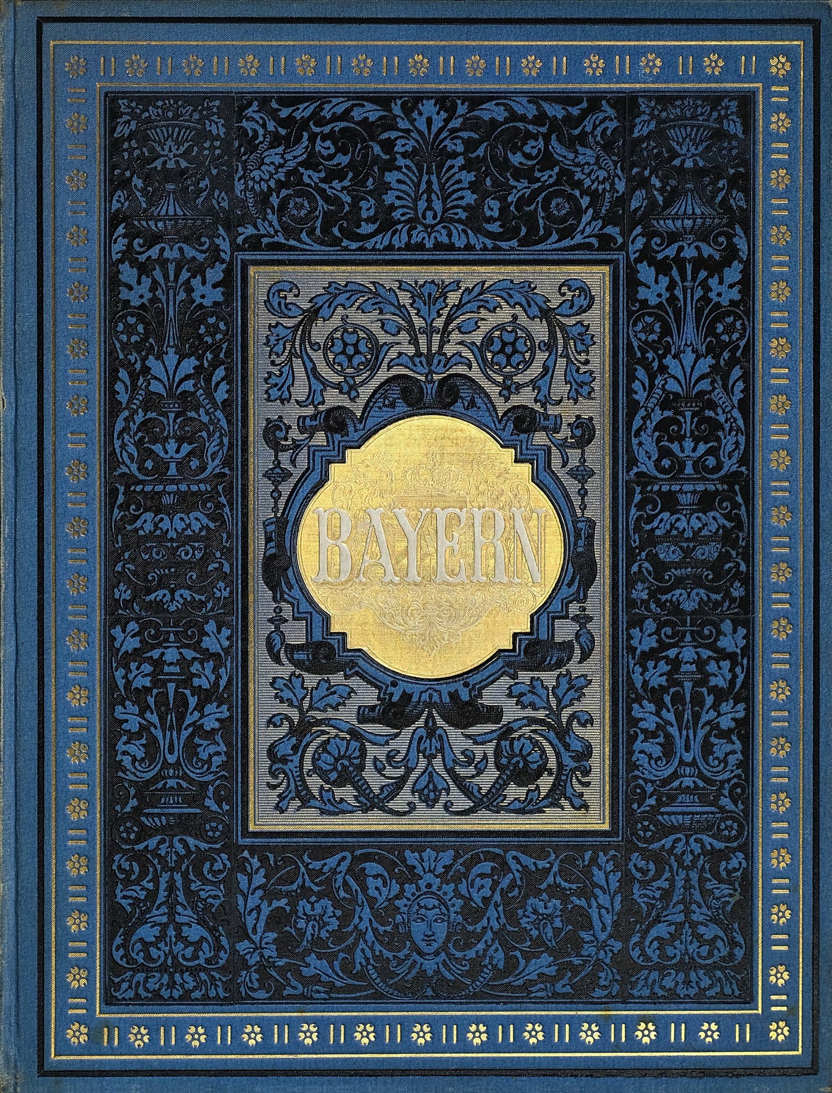 Ein blau-goldenes Buch mit der Aufschrift "Bayern", das mit kunstvollen Verzierungen geschmückt ist.