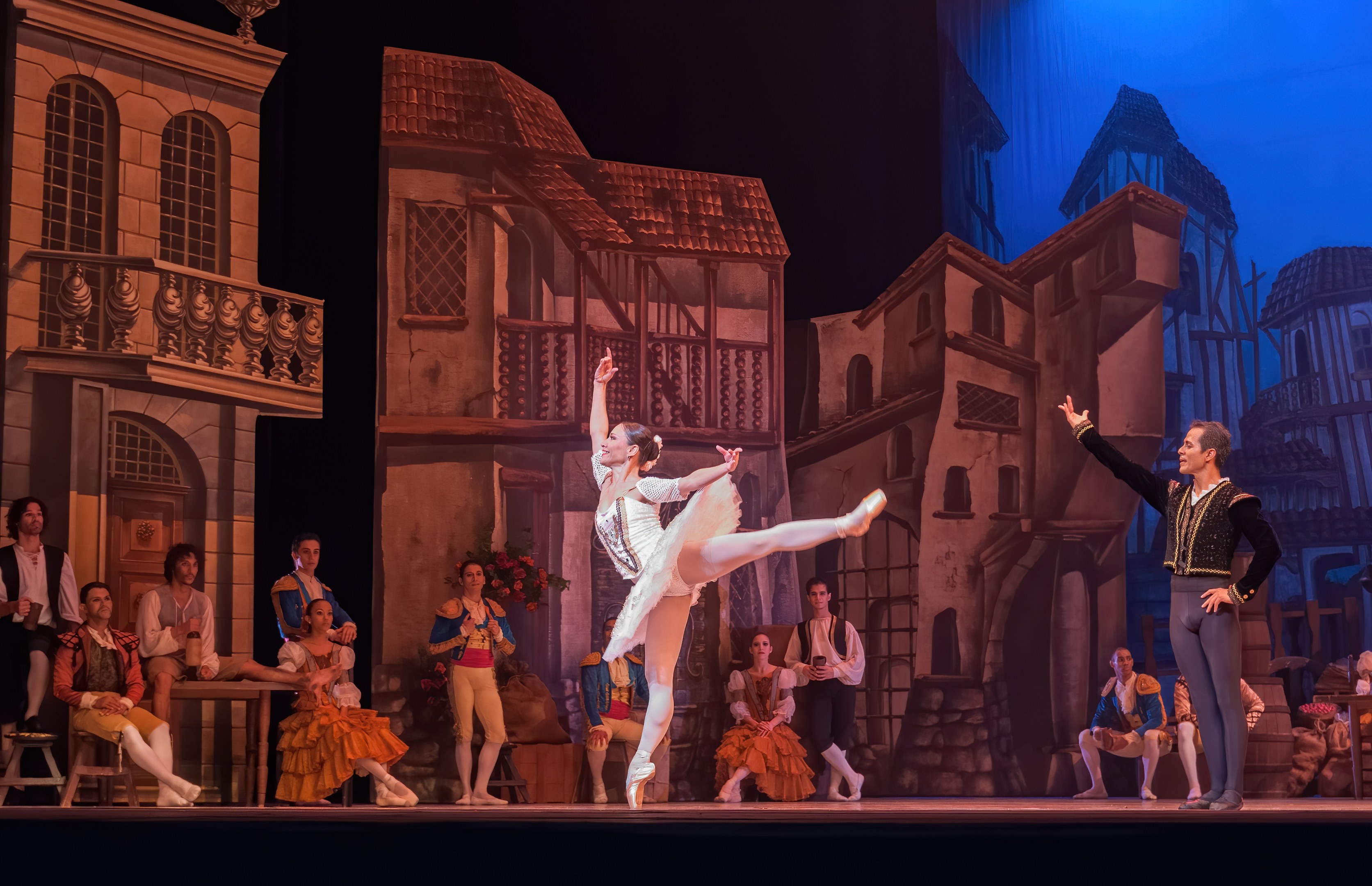 Zwei Tänzer performen auf einer Bühne im Royal Opera House in London, mit einem Publikum, das auf Stühlen und Stehplätzen sitzt.