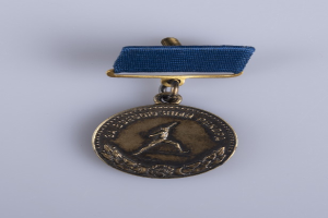 Eine goldene Medaille mit einer blauen Schleife, die eine Läuferin zeigt und mit Text beschriftet ist, die die Olympischen Spiele feiert.