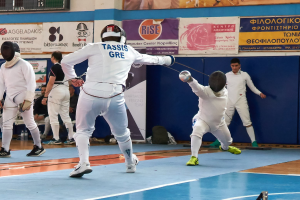 Gruppe von Fechtern in einer Turnhalle mit einer Anzeigetafel darüber, die Helme tragen und Schwerter halten, während andere auf Stühlen sitzen und Banner an der Wand hängen.