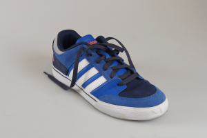 Ein Paar blaue und weiße Adidas-Schuhe mit blauen Obermaterial, weißen Akzenten, weißer Zwischensohle, blauer Außensohle, weißen Schnürsenkeln und einer blauen Zunge mit einem weißen Adidas-Logo, dargestellt auf einem weißen Hintergrund.