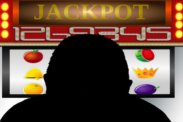 Ein Mann spielt ein Online-Slot-Spiel mit einer 'Jackpot'-Anzeige, umgeben von fruchtmotivischen Symbolen auf einem digitalen Board.