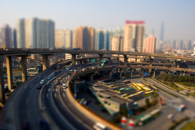 Drei Brücken mit Fahrzeugen und parkenden Bussen, mit Gebäuden darunter sichtbar.