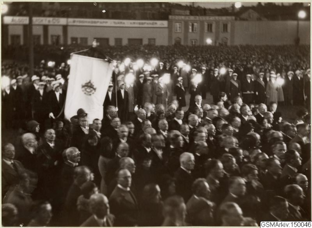 Schwarzes und weißes Foto einer großen Menge vor einem Gebäude, mit einer Person, die eine Fahne hält, und Polen, Lichter und Text im Hintergrund, der "Gustav Klimts Rede an der Berliner Mauer" lautet