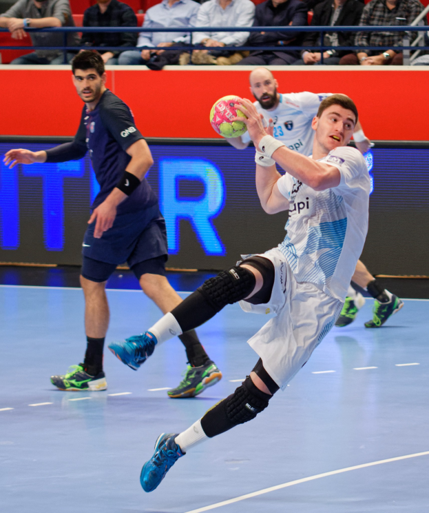 Eine Gruppe von Männern, die Handball auf einem Court während der Futsal-Weltmeisterschaft 2019 spielen, mit Zuschauern im Hintergrund und einer Anzeigetafel mit den Spieltagen.