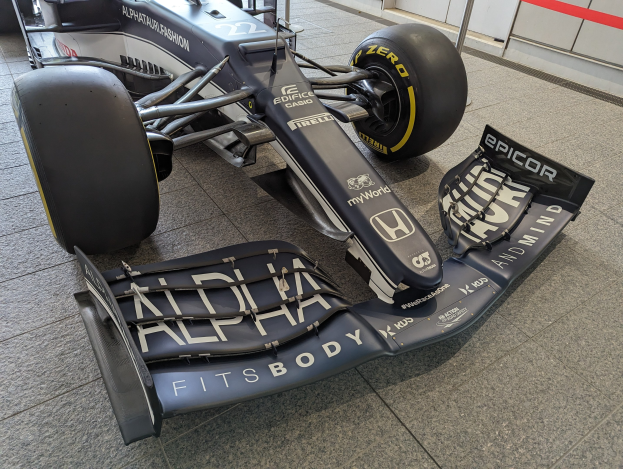 Ein schwarzer und weißer McLaren MP4-31 Formel-1-Rennwagen im McLaren Museum ausgestellt, mit einem großen Heckflügel und aerodynamischem Design.