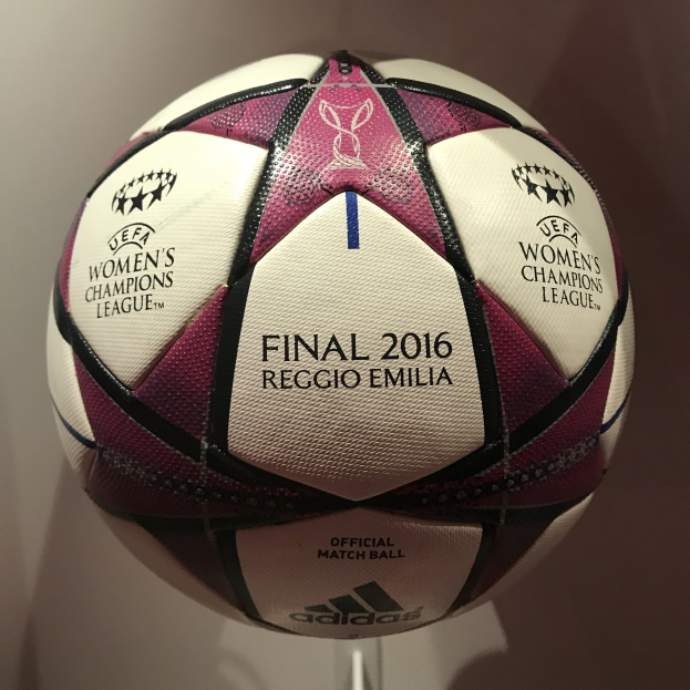 Ein Fußball auf einem weißen Tisch mit der Aufschrift 'UEFA Women's Champions League Final 2016' in Weiß, Rosa und Schwarz.