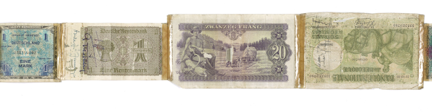 Ein altes Buch mit verschiedenen Nennungen alter deutscher Banknoten darauf gestapelt.