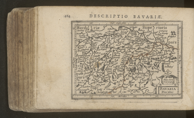 Altes Buch mit detaillierter Karte von Bayern vor schwarzem Hintergrund, die geographische Merkmale zeigt.