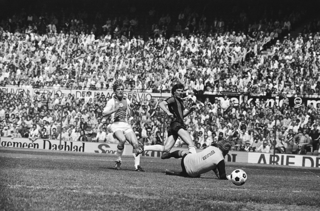 Schwarzes und weißes Foto von Fußballspielern im Einsatz auf einem Feld mit Zuschauern im Hintergrund und einer Bundesliga 1978-79 Ajax 1-1 Hannover 96-Tafel.