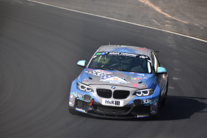 BMW M2 GT3-Rennwagen auf einer Rennstrecke mit Text und Zahlen auf der Karosserie.